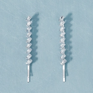 Detailed macro view of silver hair clips with tiered rectangular zircon inlay