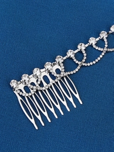Detailed close-up of a silver bridal hair comb with sparkling rhinestones on dark fabric