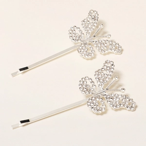 Detailed close-up of two silver butterfly hair clips with sparkling rhinestone inlay