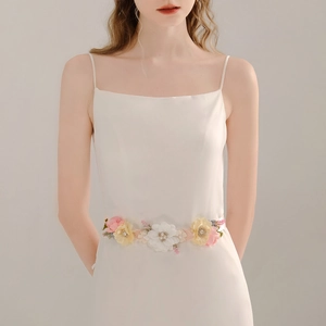 Detailed close-up of handmade bridal belt featuring pastel fabric flowers and pearls