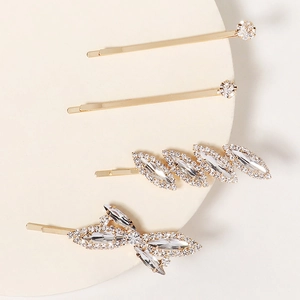 Detailed view of 4-piece gold hair clip set with sparkling rhinestones and bow design