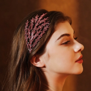 Gros plan détaillé d'un serre-tête de mariée avec strass rouges et design de branche