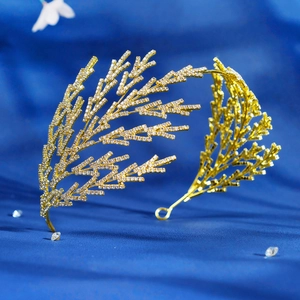 Gros plan d'une couronne de mariée dorée avec strass scintillants sur velours bleu