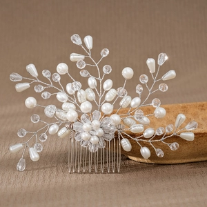 Close-up of bridal hair comb with white faux pearls and crystals on silver wire
