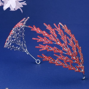 Détail d'un serre-tête de mariée argenté en forme de corail avec strass rouges