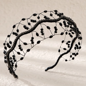 Close-up of handmade woven black crystal headband with intricate beadwork and rhinestones