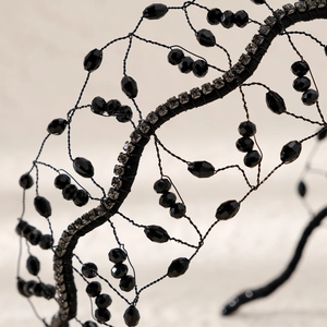 Detailed close-up of handmade black beaded bridal headband with faceted crystals and lace weaving