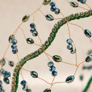 Detailed view of handmade bridal headband with gold wire mesh and blue crystal beads
