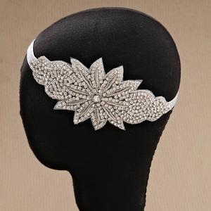 Detail of hand-sewn leaf rhinestone headband with silver base on white elastic strap