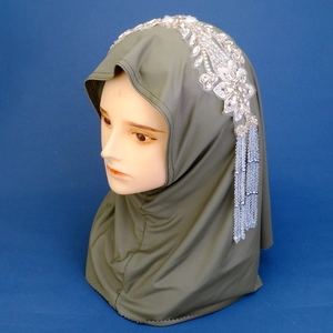 Detail of olive green hijab with floral rhinestone patch and long crystal tassels