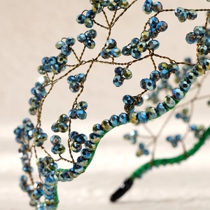 Macro detail of handmade bridal headband with blue crystals and gold wire woven design