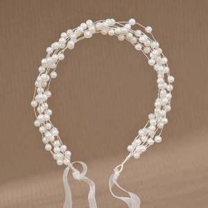 Détail d'un bandeau de mariée élégant fait main avec perles blanches et fil d'argent