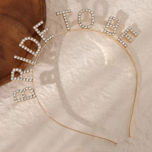 Detailed view of BRIDE TO BE lettering with sparkling rhinestones on golden alloy headband