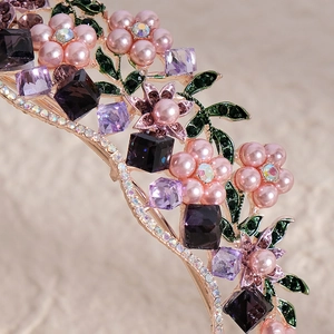 Vintage rose gold floral tiara with purple crystals and pink pearls on beige background