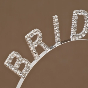 Detailed macro view of rhinestone-encrusted 'BRIDE' lettering on a silver metal headband