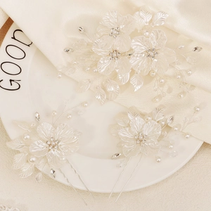 Vue détaillée du peigne et des pinces à cheveux à fleurs perlées blanches pour mariée