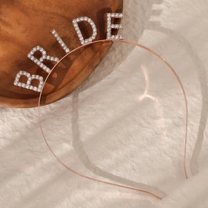Detailed macro view of rose gold rhinestone BRIDE lettering on a luxury headband
