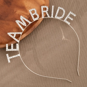Detailed view of silver Team Bride rhinestone headband on a rustic wooden tray