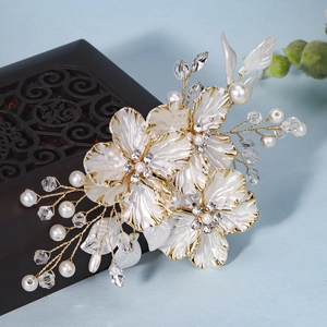 Détail d'un peigne à cheveux de mariée fait main avec fleurs perlées et fils dorés