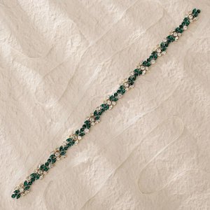 Détail de la ceinture de mariée faite à la main avec strass verts et cristaux brillants