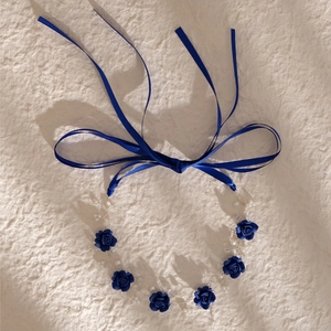 Macro view of blue roses with pearls and crystals on a handmade bridal hairband