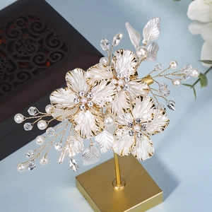 Vue détaillée d'une pince à cheveux de mariée avec fleurs en émail blanc et perles