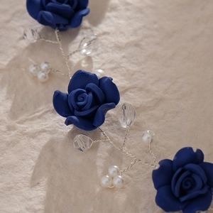 Close-up of handmade bridal headband with blue roses, pearls, and faceted crystals