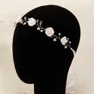 Detail of white handmade floral bridal headband with pearls, crystals and ribbon tie