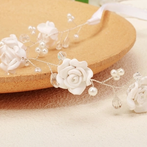 Macro detail of white roses with pearls and crystals on a bridal headband