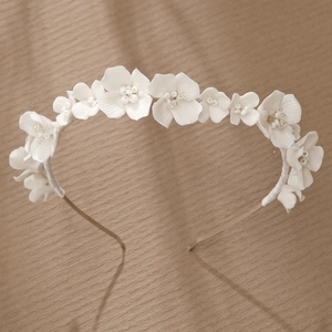 Detail of bridal headband with handmade white clay flowers and crystal beads