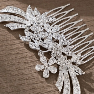Detailed close-up of silver floral hair comb with sparkling rhinestones for bridal hairstyle