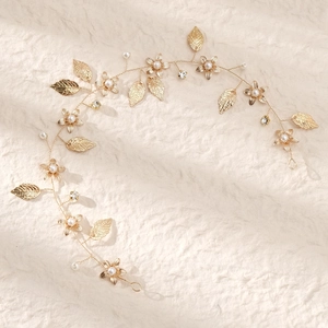 Detail of handmade gold bridal hair vine with metallic leaves pearls and crystals