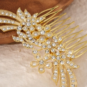 Macro detail of golden bridal hair comb featuring floral patterns and sparkling rhinestones