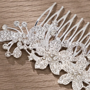 Close-up of silver bridal hair comb with intricate floral rhinestones and leaf details