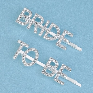 Macro shot of silver BRIDE TO BE hair clips set with sparkling rhinestones for weddings