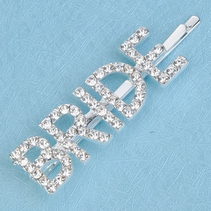 Detailed view of silver bobby pin with BRIDE lettering in sparkling rhinestones