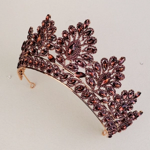 Detailed top view of a rose gold bridal crown featuring deep red marquise crystals