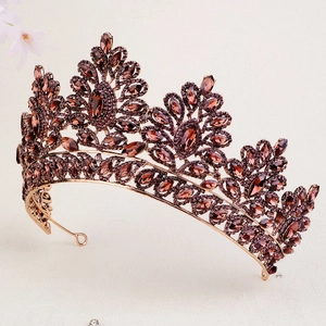 Detailed macro shot of vintage rose gold crown with amber rhinestones and baroque patterns