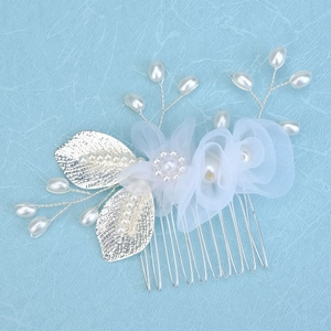 Détail d'un peigne à cheveux pour mariée avec fleurs en résille, feuilles et perles blanches
