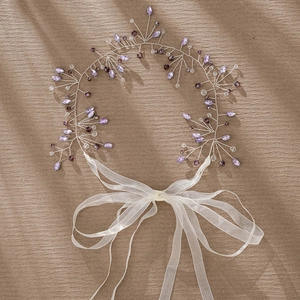 Detailed shot of handmade silver wire bridal headpiece with purple crystal beads and ribbon