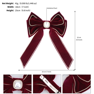 Detail view of red velvet bow hair clip with rhinestone edges and a center pearl charm