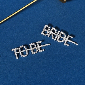 Détail des barrettes en strass TO BE BRIDE sur un fond bleu texturé élégant