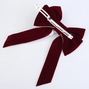 Detailed back view of a red velvet bow hair clip with a sturdy silver metal spring clip