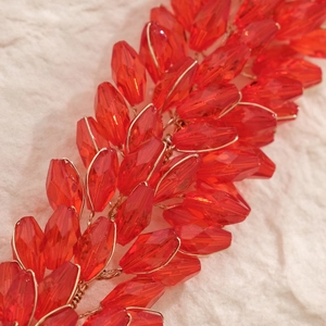 Vue macro d'un bandeau de mariée en cristal rouge fait main avec fil doré et perles