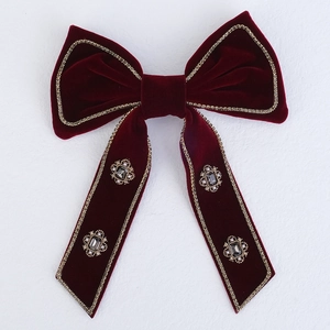 Detail of red velvet bow hair clip with gold rhinestone trim and vintage crystal charms