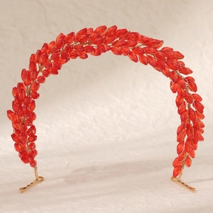 Détail du serre-tête rouge avec cristaux facettés et tressage délicat en fil doré