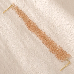 Détail d'un bandeau de mariée artisanal avec perles de cristal ambre et clips dorés