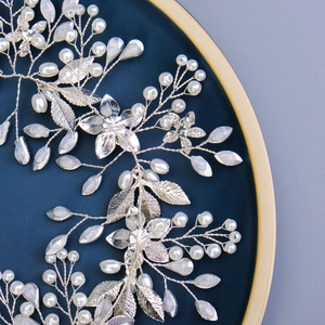 Close-up of pearl bridal belt with silver metal leaves and rhinestone floral details