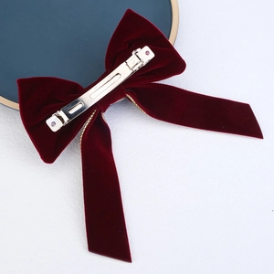 Close-up of vintage wine red velvet bow hair clip with silver metal spring fastener