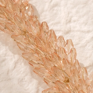 Détail macro d'un bandeau de mariée avec perles de cristal rose et fils dorés